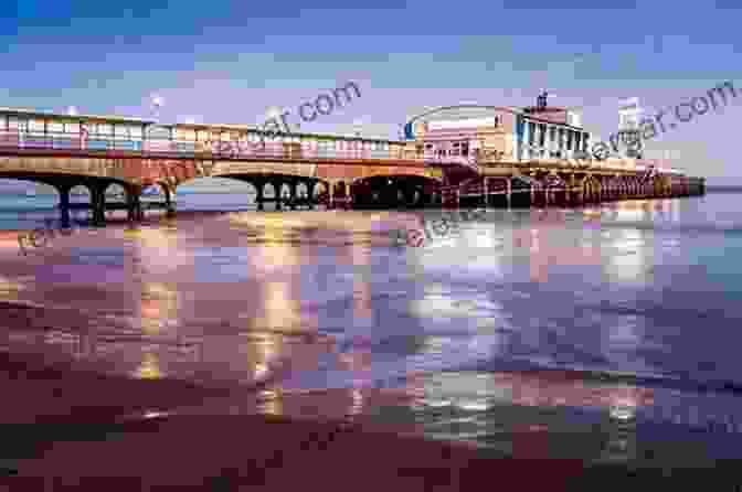 A Vibrant Seaside Pier Bustling With Visitors, Capturing The Essence Of British Seaside Culture Walking Over The Waves: Quintessential British Seaside Piers